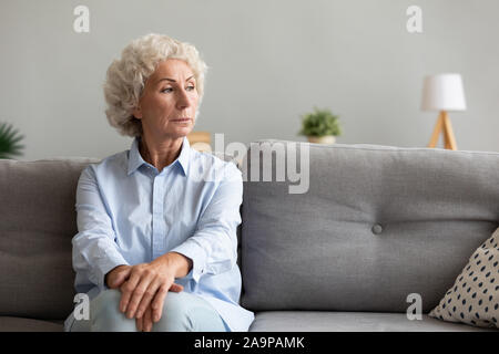 À la grand-mère senior pensif pensant de solitude on couch Banque D'Images