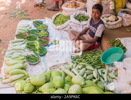 Jeune garçon vente de légumes au marché du dimanche de Tiruchirappalli, Tamil Nadu, Inde Banque D'Images