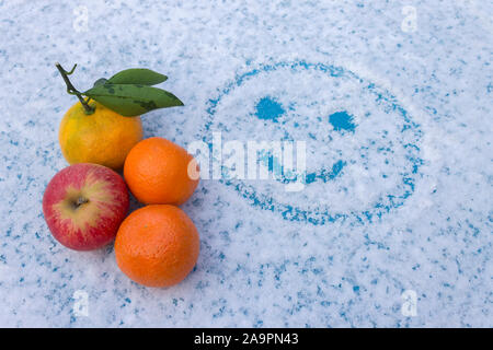 Un ensemble de fruits se trouve sur une table avec un visage souriant, peint Banque D'Images