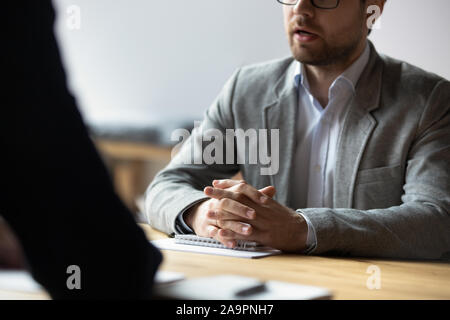 Close up young businessman sitting at table avec les mains jointes. Banque D'Images