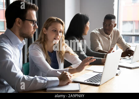 Les plus jeunes et les plus vieux multiraciale collègues travaillant en paires dans Office. Banque D'Images