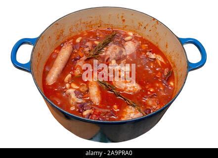 Poulet, saucisses, bacon et haricots cassoulet dans un grand pan bleu sur un fond blanc isolé Banque D'Images