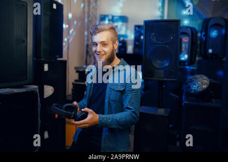 Jeune musicien choisissant les écouteurs en music store Banque D'Images