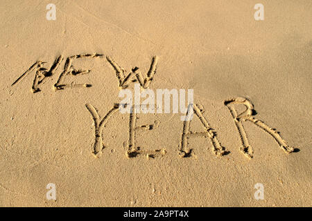 Nouvelle année mot sur le sable de la plage. Nouveau concept de l'année. Vacances à la plage. Nouvelle année de phrase est écrite sur un sable Banque D'Images
