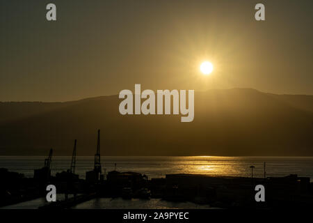 Lever du soleil au port de Messine avec soleil au-dessus des montagnes de Calabre, Italie Banque D'Images