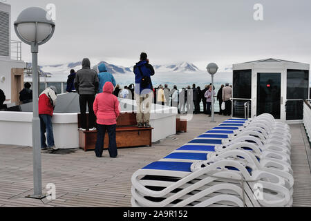 Les passagers sur le pont d'un bateau de croisière naviguant au-delà de l'Lilliehookbreen glacier sur la côte ouest du Spitzberg (latitude 79.20N). Banque D'Images