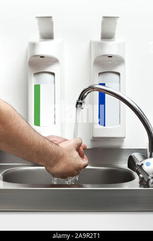 Un beau jeune homme s'en lave les mains Banque D'Images