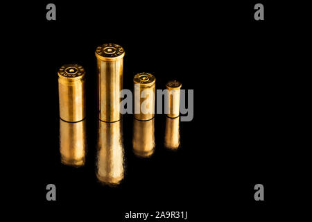 Comparaison de différentes tailles d'utilisé des obus sur une balle de fond isolé noir avec la réflexion d'une tin de table. Perception de la qualité Banque D'Images