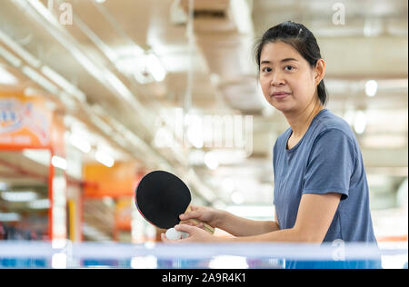 Femme Asiatique est à jouer au tennis de table ou ping-pong dans la salle de sport. Banque D'Images