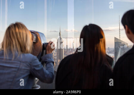 New York, USA - 17 mai 2019 : Rear View of Woman Peering Through Viseur Binoculaire à New York du Haut de la roche Banque D'Images