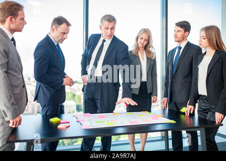 L'équipe Creative business plans de travail discuter à l'aide de Post-it de couleur Banque D'Images