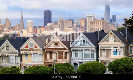 Vue sur le Painted Ladies victorian maisons en rangées avec l'horizon de San Francisco dans l'arrière-plan d'Alamo Square Park à San Francisco, Californie Banque D'Images