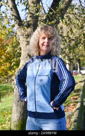 Mature femme d'âge moyen portant un retro Adidas Tracksuit top réalisés dans les années 1970 Photographie prise par Simon Dack Banque D'Images