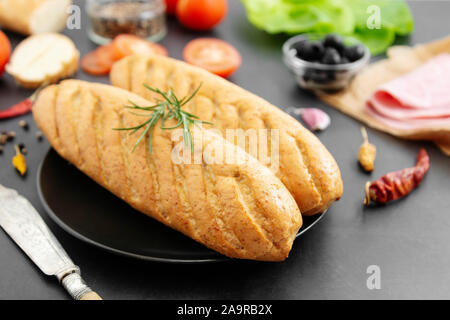 Baguette de pain long close up, du pain et des ingrédients alimentaires pour sandwich. Petit-déjeuner de cuisson ou la restauration rapide. Banque D'Images