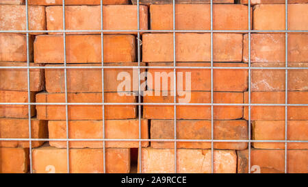 La texture de fond-close up of vintage remis en briques rouges empilés dans une cage en métal Banque D'Images