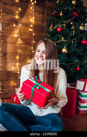 Belle femme posant dans la salle entourée par des cadeaux de Noël. Banque D'Images