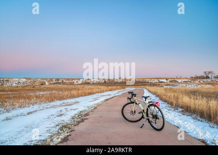 Vélos de cyclotourisme au crépuscule ou à la fin de l'automne paysage d'hiver - l'un des nombreux sentiers de vélo de Fort Collins, dans le nord du Colorado, des loisirs et des déplacements d'hiver Banque D'Images