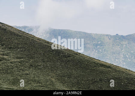 Un homme est la randonnée sur la colline de Monte Tamarao avec du brouillard en arrière-plan Banque D'Images