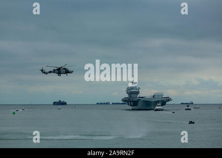 HMS Prince de Galles arrivant à Portsmouth sa nouvelle maison. La foule recueillie par une froide après-midi de novembre pour accueillir le navire de guerre massive. Banque D'Images