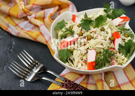 Salade saine avec le chou chinois, les conserves de petits pois et de bâtonnets de crabe dans un bol sur un fond sombre, l'orientation horizontale Banque D'Images