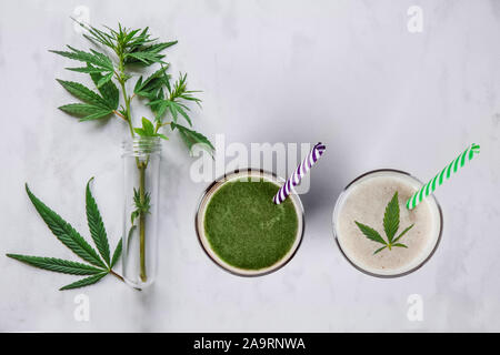 Smoothie concept avec le cannabis et CBD. Lunettes avec des boissons fraîches, du lait et des smoothies, avec le chanvre. Mise à plat. Banque D'Images