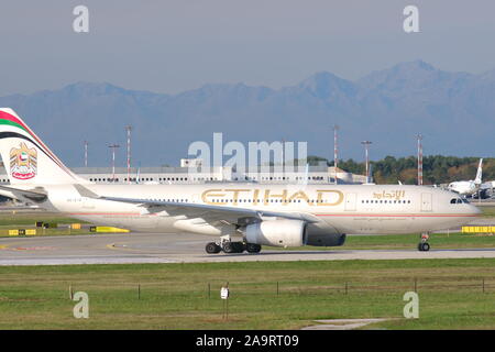 Malpensa, Lombardie, Italie. À propos de 10/2019. Airbus A330-243 d'Etihad avion manoeuvrant sur la piste de l'aéroport de Malpensa. Dans l'arrière-plan les bâtiments Banque D'Images