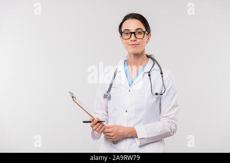 Jolie jeune confiant clinicien dans blanchon holding clipboard avec le document Banque D'Images