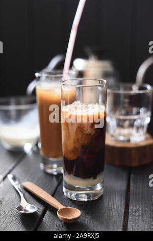 Beaux tourbillons de lait de coco en vietnamien café glacé dans des grands verres sur fond sombre copy space Banque D'Images