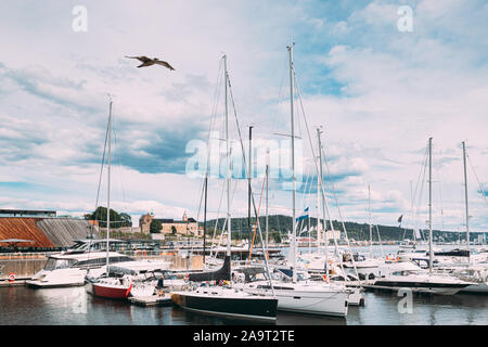 Oslo, Norvège. Bateaux et yachts amarrés au quartier Aker Brygge. Seascape de port et quais de journée d'été sous Scenic ciel nuageux. Banque D'Images