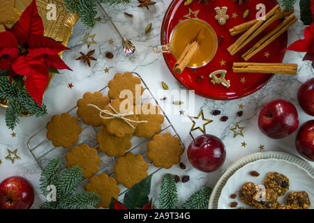La photographie de l'alimentation d'une table en marbre décoré de rouge et or chic chic les cookies de Noël et épices Banque D'Images
