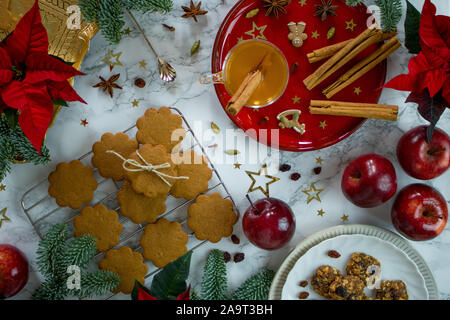 La photographie de l'alimentation d'une table en marbre décoré de rouge et or chic chic les cookies de Noël et épices Banque D'Images