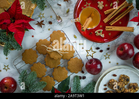 La photographie de l'alimentation d'une table en marbre décoré de rouge et or chic chic les cookies de Noël et épices Banque D'Images