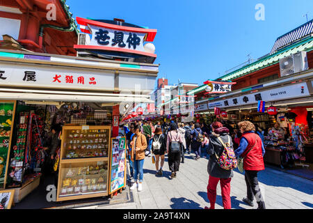 Tokyo, Asakusa shrine et temple Sensoji. La rue Commerçante Nakamise souvenir avec les gens et les touristes en passant devant l'alimentation et des boutiques de souvenirs, ciel bleu. Banque D'Images