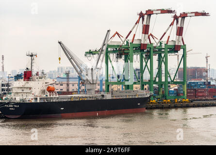 Ho Chi Minh City Vietnam - 12 mars 2019 : chanson fleuve Sai Gon. Centre-ville de port. Noir-rouge Pulang Tala cargo navire amarré sur le quai sous le ciel d'argent. Green- Banque D'Images