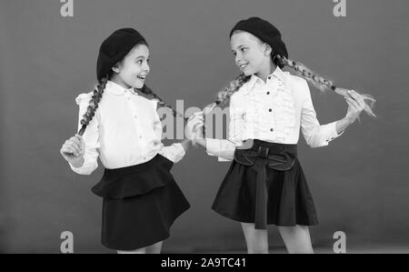 Style de fantaisie. L'École de l'amitié. Sur la même vague. Usure uniforme de l'école formelle écolières. Les enfants belles filles de long cheveux tressés. Peu de filles avec des tresses, des prêts pour l'école. Concept de la mode de l'école. Banque D'Images