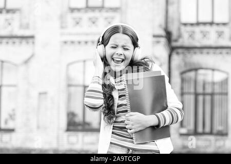 Cette chanson est une célébration de la joie. Happy little girl à chanter sa chanson préférée. Petit enfant jouit d'un morceau de l'école jouant dans des écouteurs. Nouvelle chanson et de nouvelles émotions. Banque D'Images