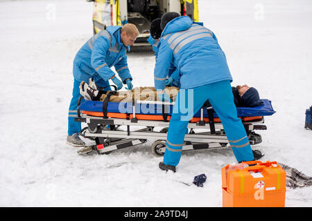 Fixation des paramédics homme inconscient sur une civière pour le faire pour ambulance Banque D'Images