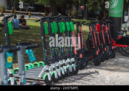 Lisbonne, Portugal - 11 AOÛT 2019 : une sélection de scooters électriques à l'extérieur de Lisbonne disponibles à la location à l'aide d'une application pour smartphone. Les gens peuvent être vus. Banque D'Images