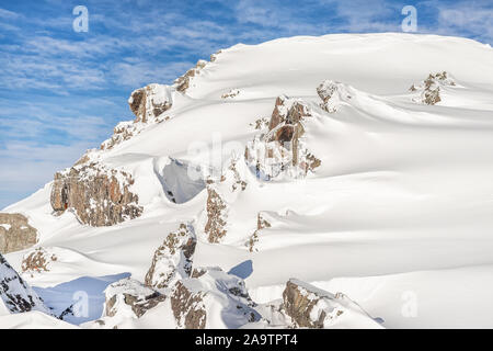 Alpine pittoresque pic de montagne couverte de neige épaisse et d'une couche de roches sur la journée ensoleillée. La nature sauvage de l'hiver. Le domaine de ski de neige vierge Banque D'Images