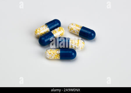 Capsules bleu et jaune sur fond gris clair. Concept de la drogue. Banque D'Images