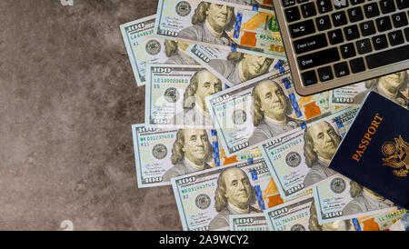 Une centaine de dollars de l'argent comme un ordinateur portable sur l'achat en ligne de billets avec passeport américain, Banque D'Images