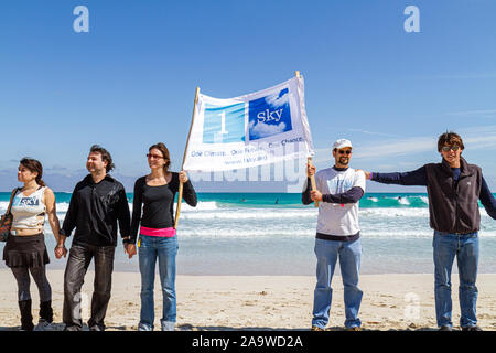 Miami Beach Florida,Fondation Surfrider,pas de protestation de forage pétrolier offshore de Floride,vêtements noirs représente le pétrole,tenir la main,mains,panneau,Océan Atlantique,wa Banque D'Images