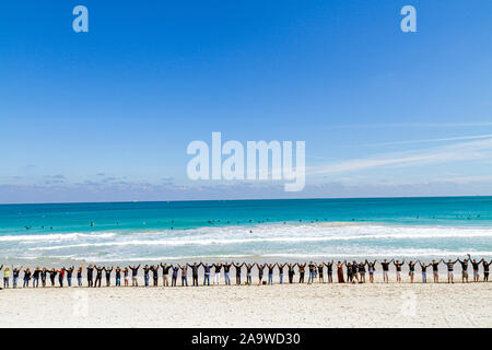 Miami Beach Florida,Fondation Surfrider,pas de protestation de forage pétrolier offshore de Floride,vêtements noirs représente le pétrole,tenir la main,mains,unité,Océan Atlantique,W Banque D'Images