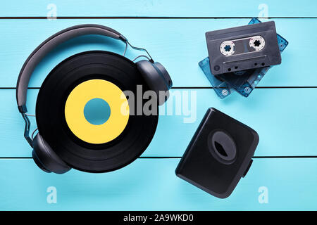 Vintage vinyl record, casque, lecteur de cassettes et des cassettes sur table en bois. Concept de 80s music audio à l'écoute. Banque D'Images