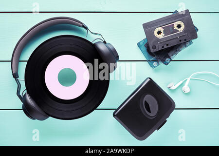 Vintage vinyl record, casque, écouteurs, lecteur de cassettes et des cassettes sur table en bois. Concept de 80s music gadgets. Banque D'Images