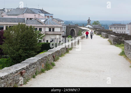 Deux hommes à pied le long du sentier sur le remparts romains de Lugo en Lugo, Espagne. Dans la distance est la Puerta del Obispo Odoario. La ville antique, célèbre pour Banque D'Images