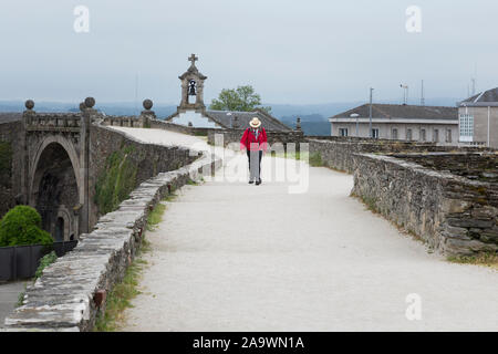 Un homme marche le long du sentier sur le remparts romains de Lugo en Lugo, Espagne. Dans la distance est la Puerta del Obispo Odoario. La ville antique, célèbre pour Banque D'Images