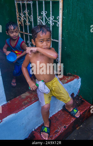 Un enfant joue avec l'eau pendant le festival de Higantes à Angono Philippines Banque D'Images