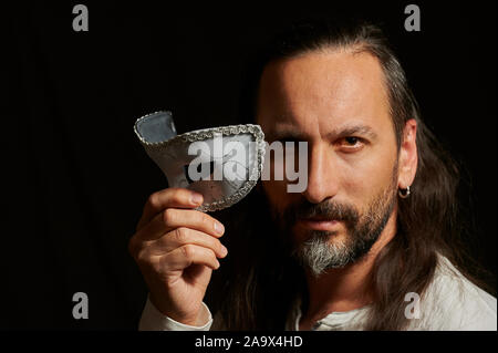 Portrait of a middle-aged man holding à poil long un masque de Venise Banque D'Images