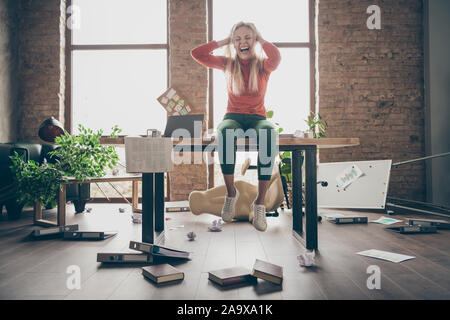 Photo pleine longueur de mad occupé freelancer secrétaire avec une humeur négative faite erreur tiré s'asseoir sur la table se sentent surchargés yell touch cheveux blonds en désordre Banque D'Images